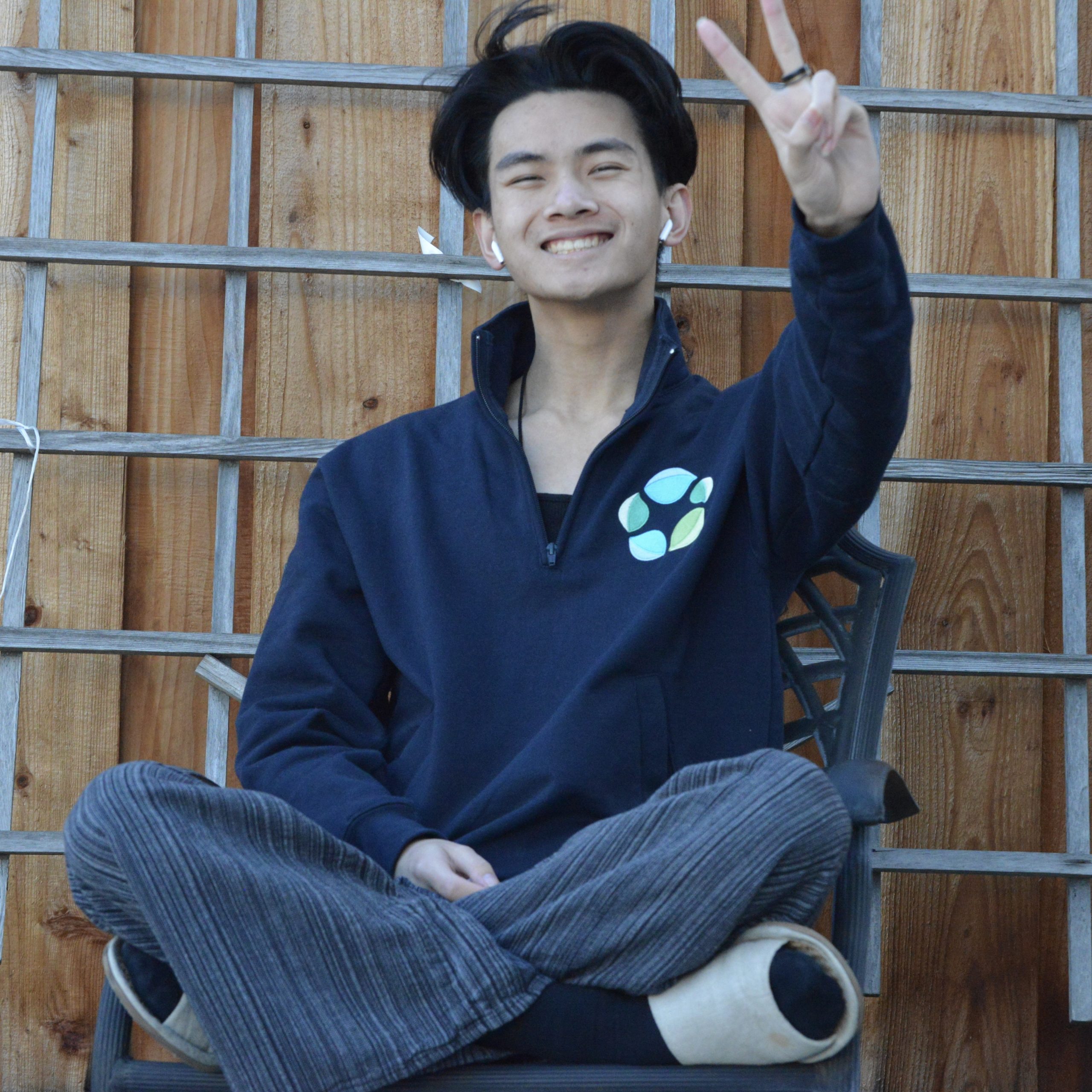 Photo of Daniel L. Tong. He's holding up a peace sign.